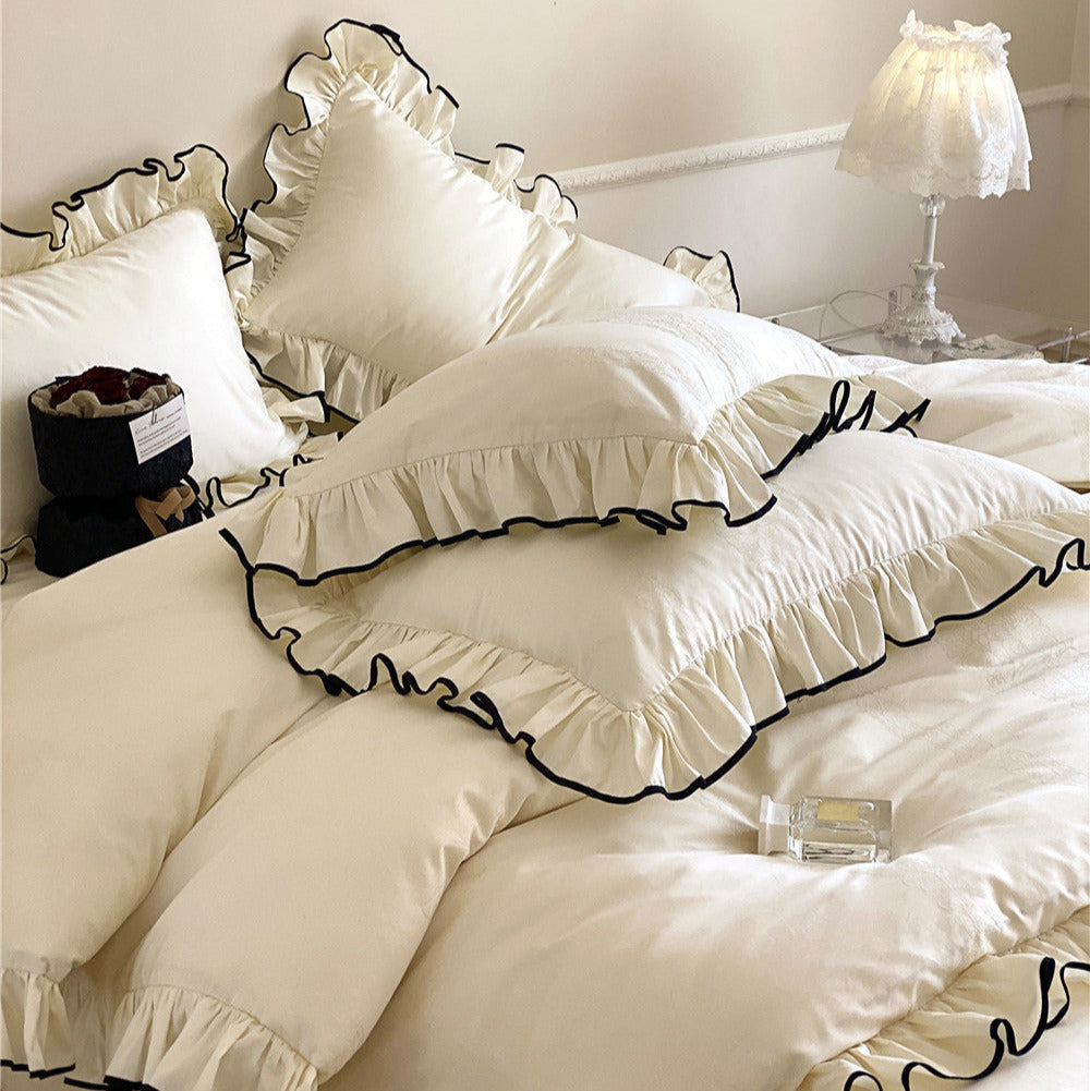Elegant ivory bedding set with ruffled trim and matching pillowcases