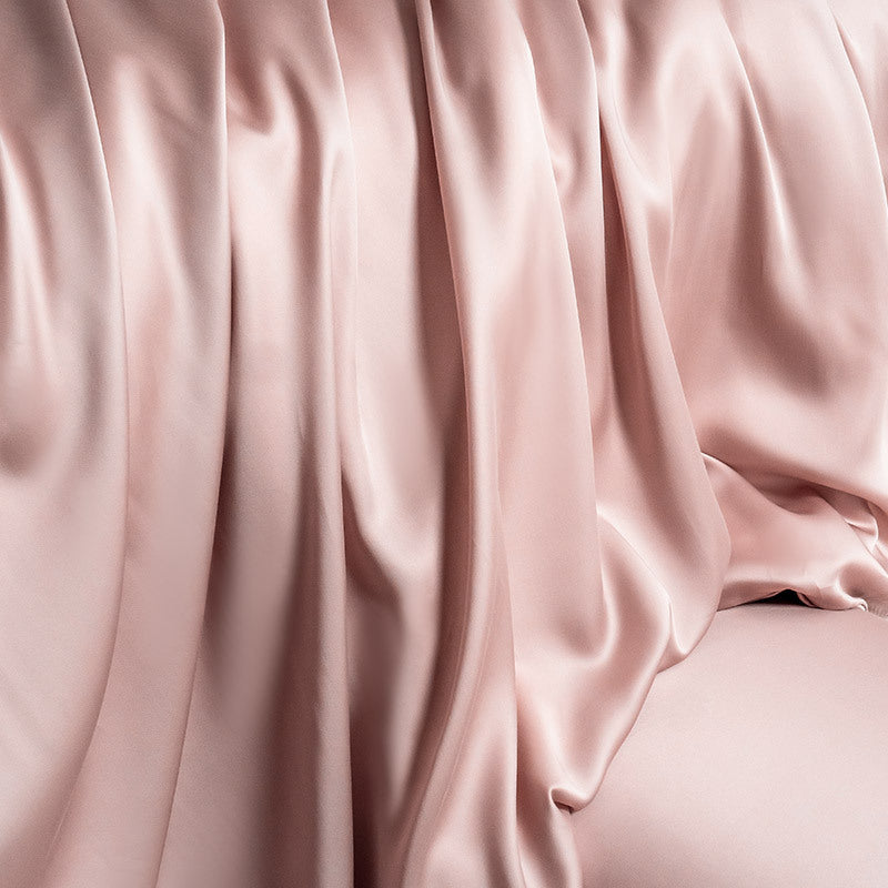 Close-up shot of the luxurious rose pink silky Lyocell duvet cover, highlighting its smooth texture and elegant, natural drapes.