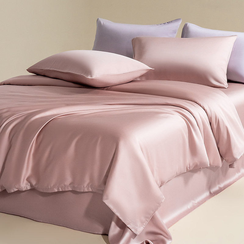 Soft and luxurious silky Lyocell bedding set in rose pink, with light purple and white pillows, showcasing the overall elegant and cozy feel.