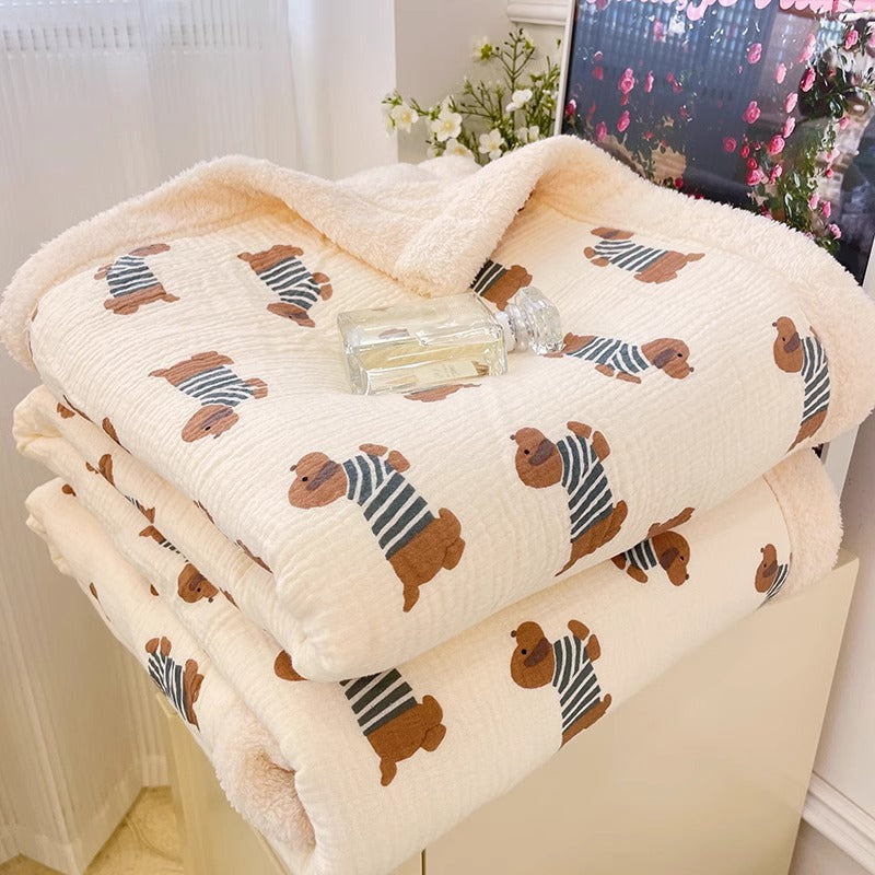 A soft fleece kids blanket with a playful dog pattern, folded and ready for a cozy winter.