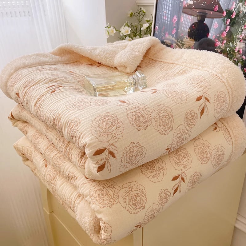 A soft fleece throw blanket with an elegant rose floral pattern, perfect for staying warm and cozy.