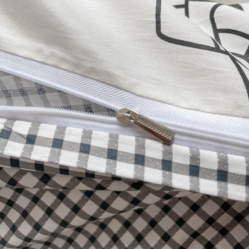 A close-up shot of the zipper on the reversible space duvet cover, revealing a black and white checked pattern on the reverse side.