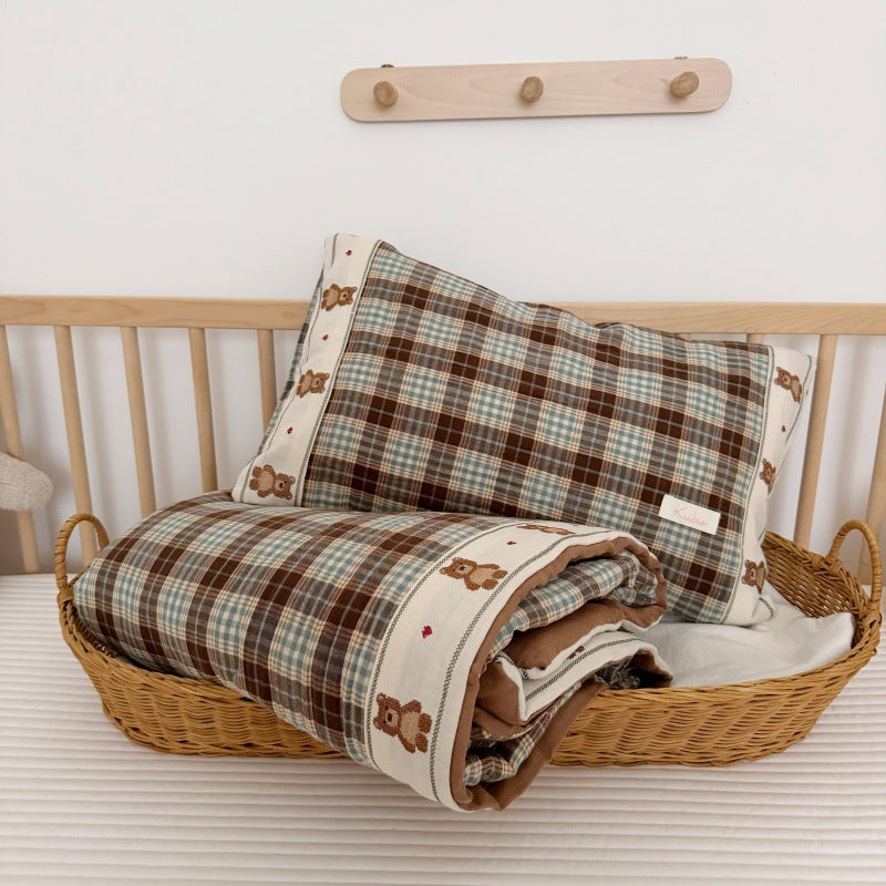 Full top view of blue and brown teddy plaid kids comforter set on a white surface