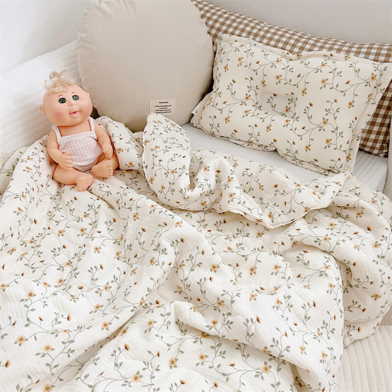 Cotton baby quilt with daisy vine pattern styled on toddler bed