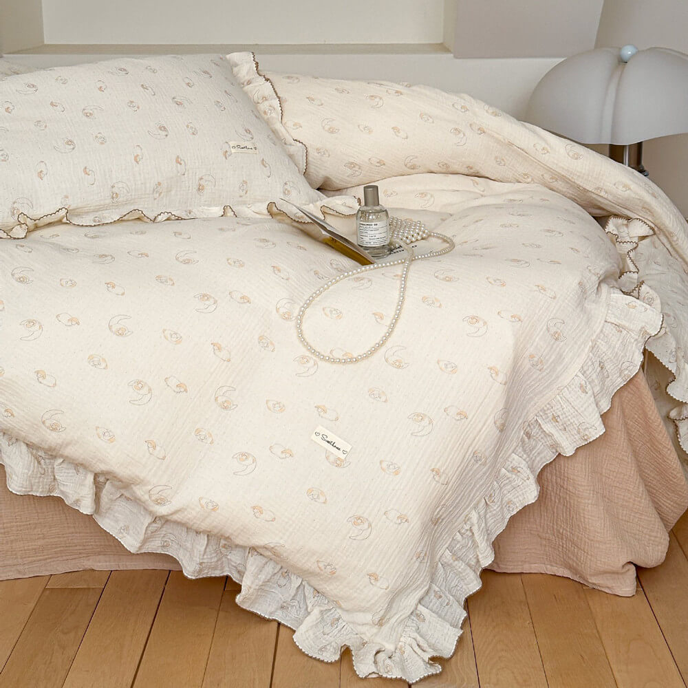 A twin bed with a creamy beige ruffled duvet cover and pillowcase, featuring a cute sheep and moon print.