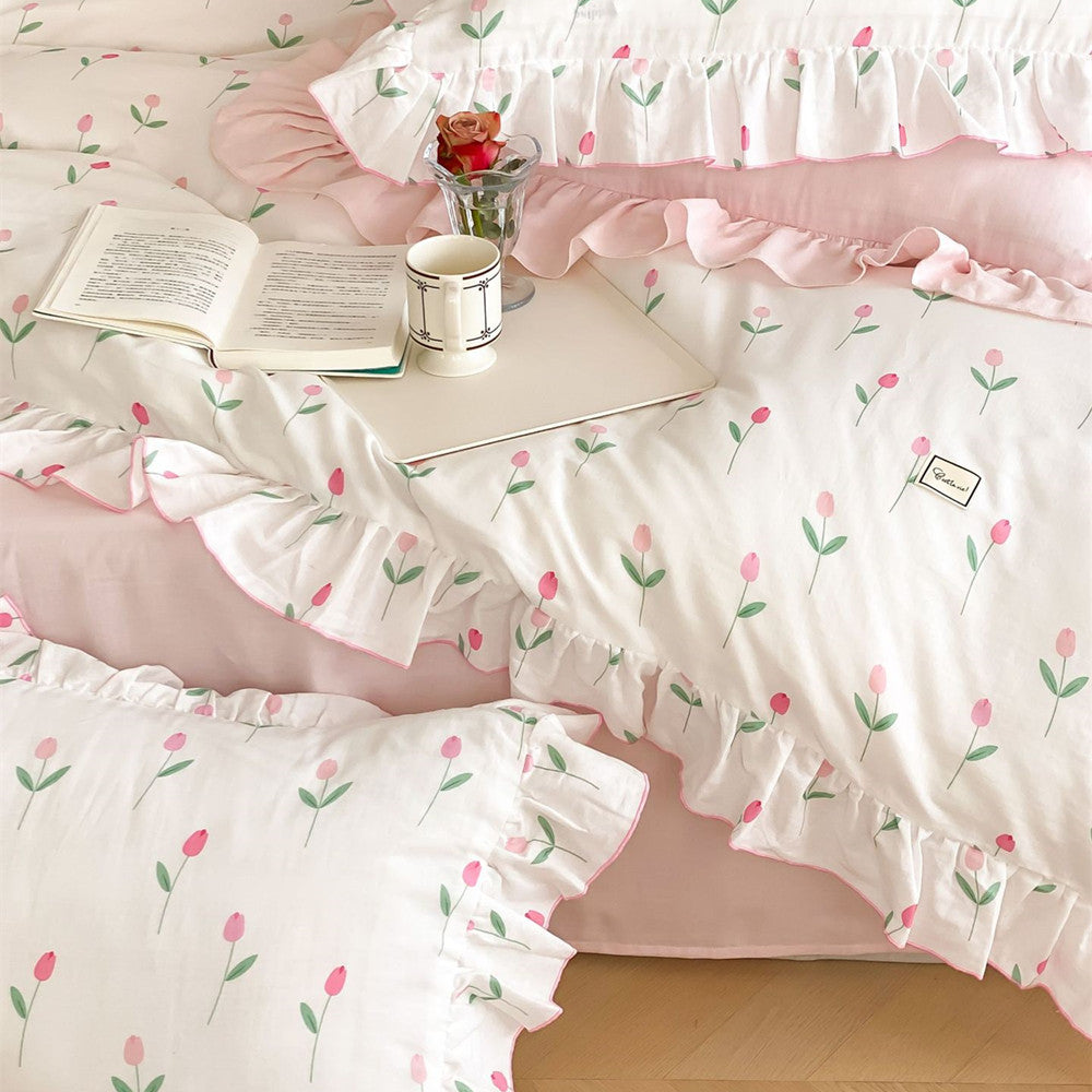 A close-up view of the pink tulip print ruffled duvet cover and matching pillowcase, styled on a bed.