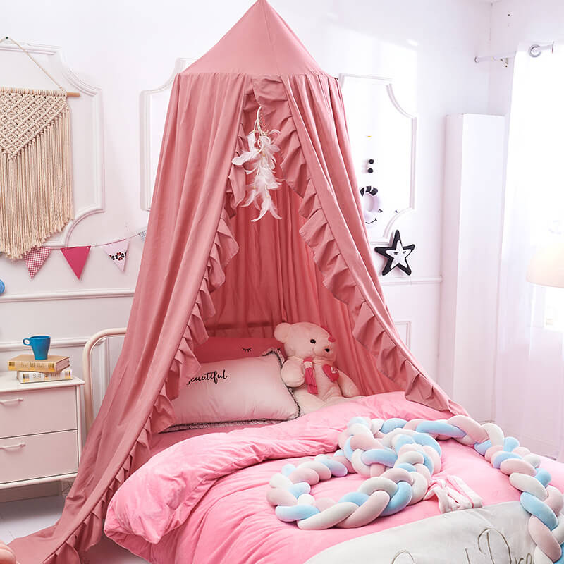 Pink ruffled polyester bed canopy for a twin bed in a girl's room.