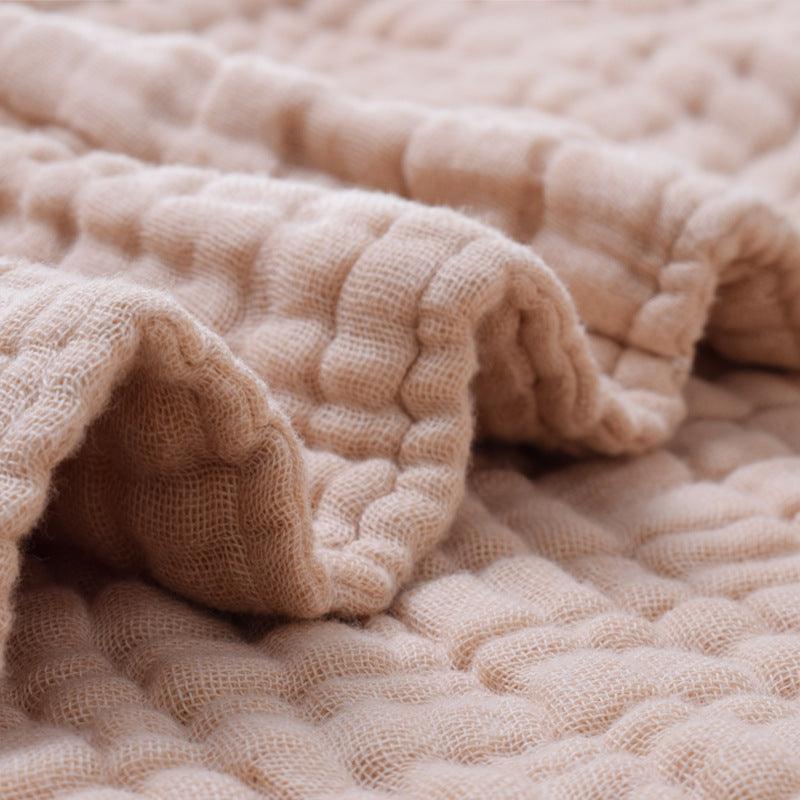 Detailed view of the crinkled texture on a 6-layer organic colored cotton muslin baby blanket, emphasizing its breathability and softness.
