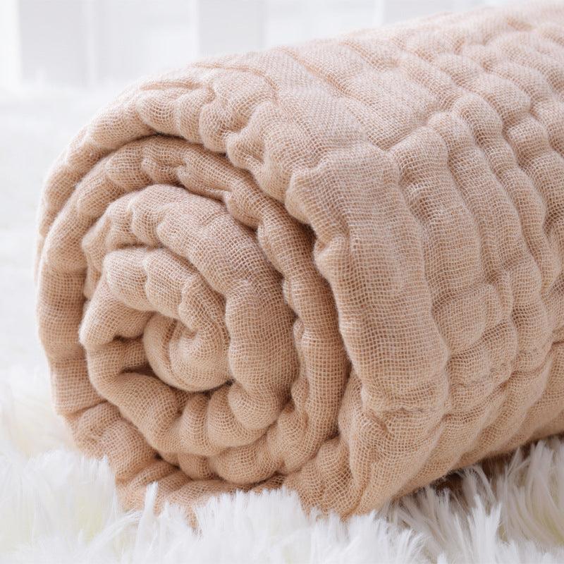 Close-up of a rolled-up 6-layer organic colored cotton muslin baby blanket, highlighting the plush, thick and soft texture.