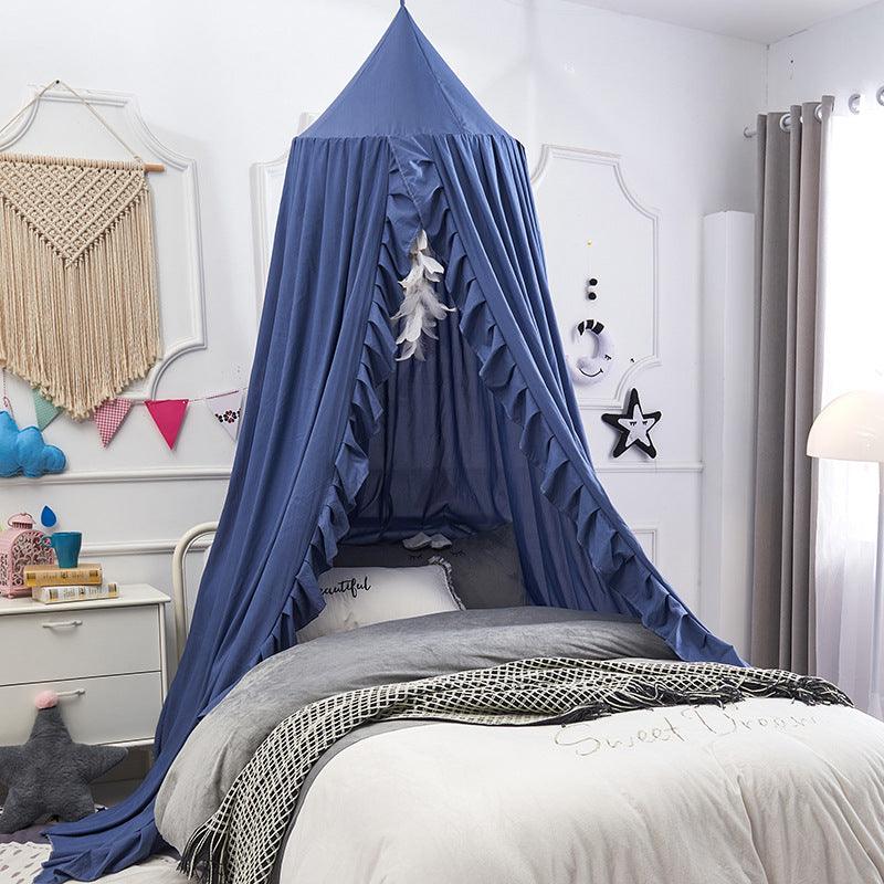 Blue ruffled polyester bed canopy hanging over a twin bed in a nursery.