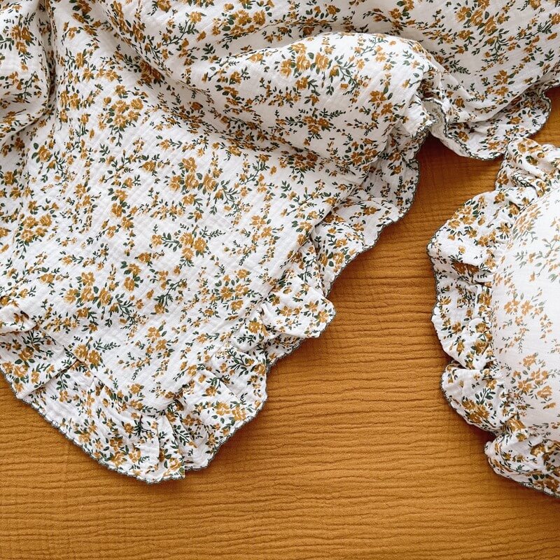 Close-up of cotton muslin hibiscus floral bedding with delicate ruffles
