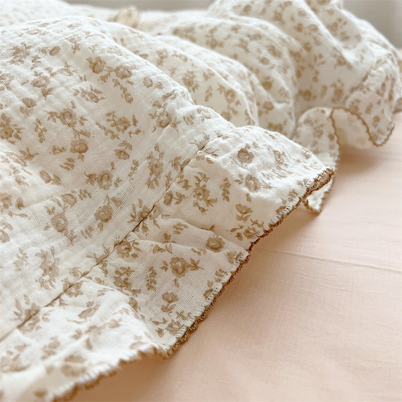Close-up of camellia floral print and ruffled edge on cotton muslin duvet cover
