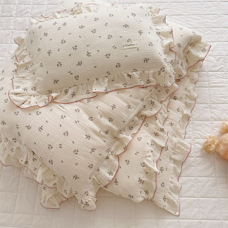 Stack of primrose floral ruffle bedding and pillowcases in soft cotton muslin