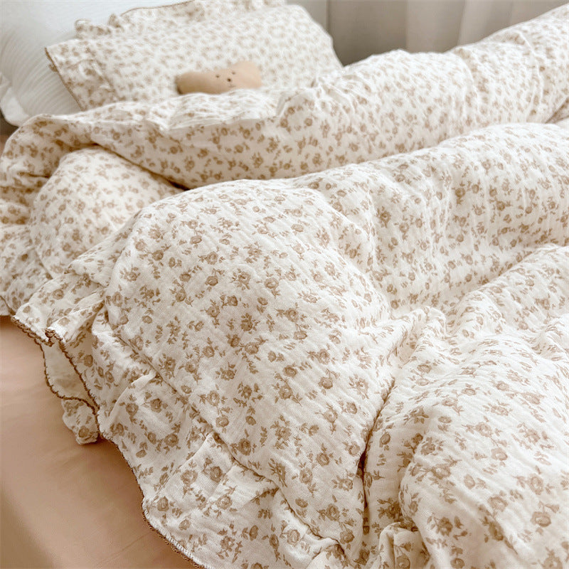 Pillowcase with matching camellia floral print and soft ruffle, displayed on cozy bedding