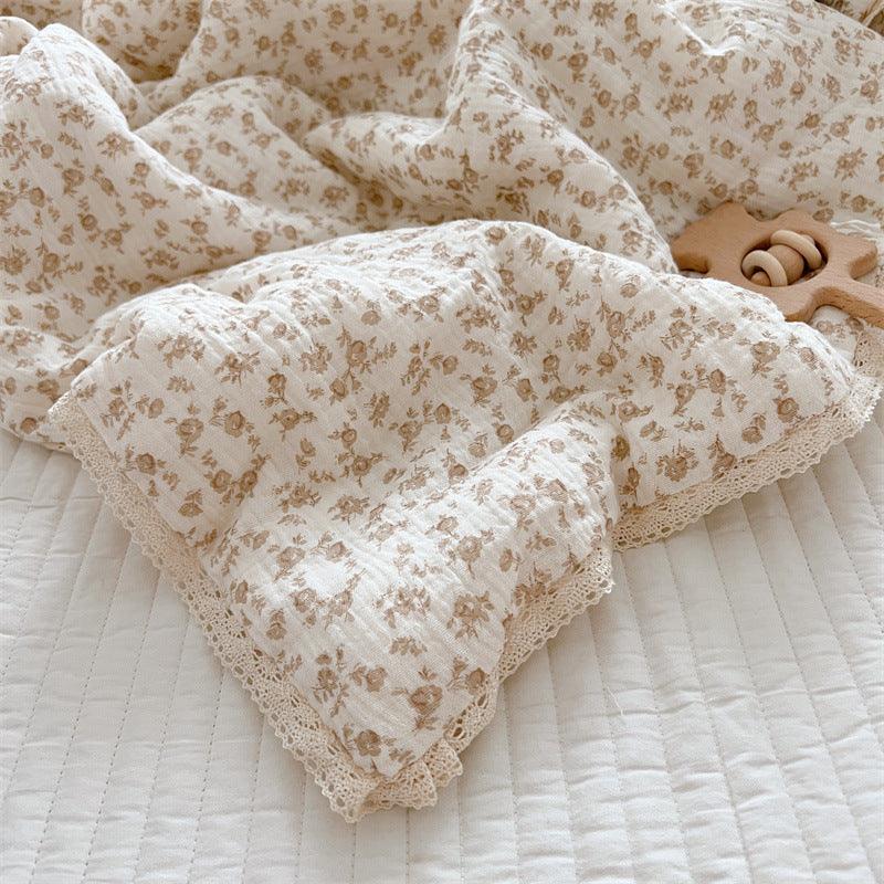 Close-up of cotton floral crib quilt with lace trim