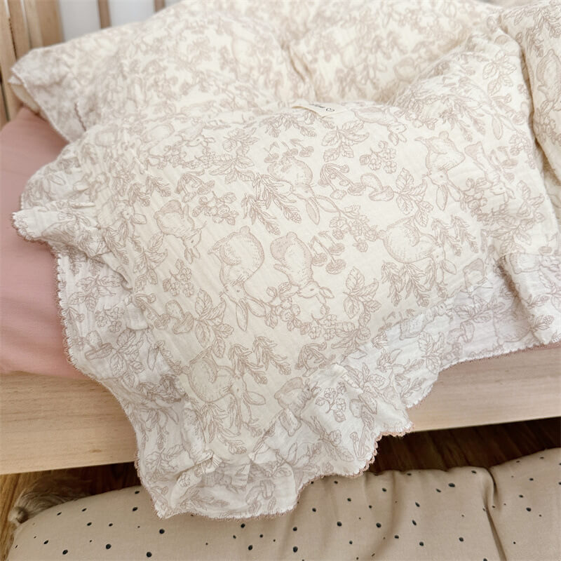 Close-up of woodland print bedding showing bunny, mushrooms, and flowers on cotton muslin