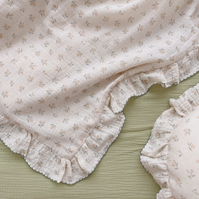 Close-up of soft floral cotton muslin fabric with ruffled trim on duvet cover