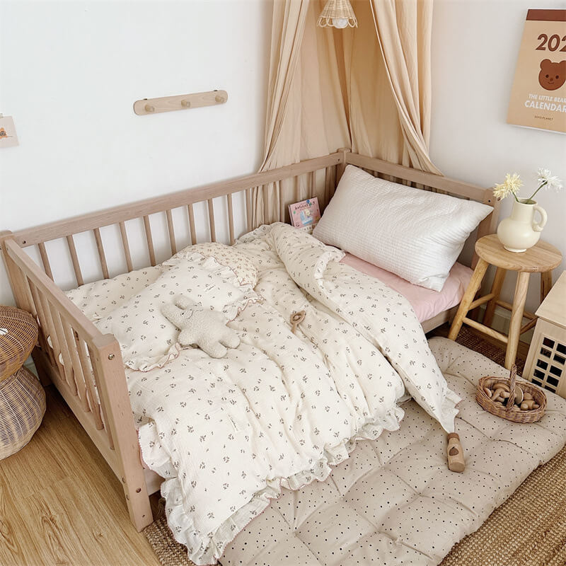 Kids’ room with primrose floral ruffle duvet cover set, pink sheet, and natural wood furniture