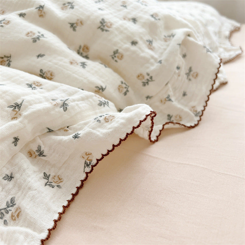 Close-up of ruffled edge and rose print on cotton muslin duvet cover set