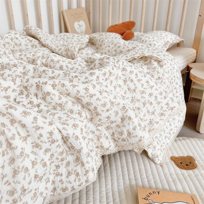 sideview of floral cotton gauze crib quilt