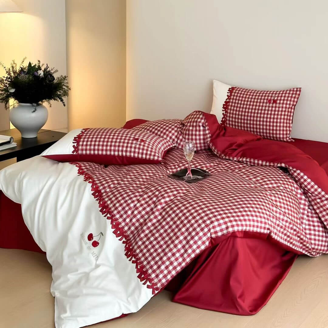 Bed with red and white checkered bedding in a bedroom setting.