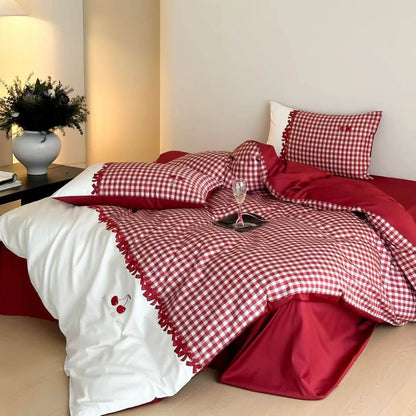 Bed with red and white checkered bedding in a bedroom setting.