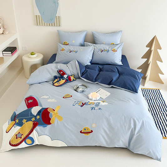 Children's bedroom with blue bedding set featuring airplane and space ship designs.