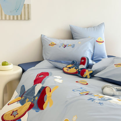Children's bed with blue bedding featuring airplane designs and colorful text.