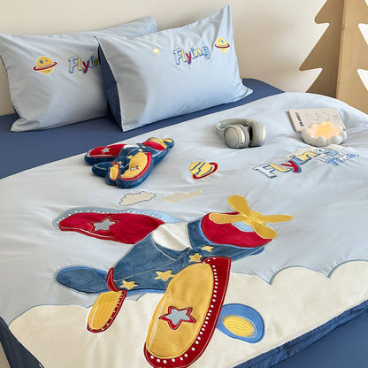 Children's airplane-themed bedding set with pillows and toys on a bed.