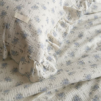 Side view of pillow and comforter showing floral pattern and double ruffles
