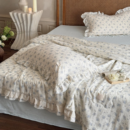 Neatly arranged pillows and comforter in soft floral cotton gauze