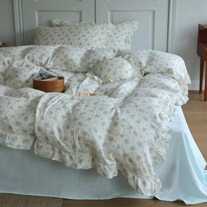 Blue posy bedding styled in a cozy teen bedroom with ruffled duvet cover and pale blue sheet