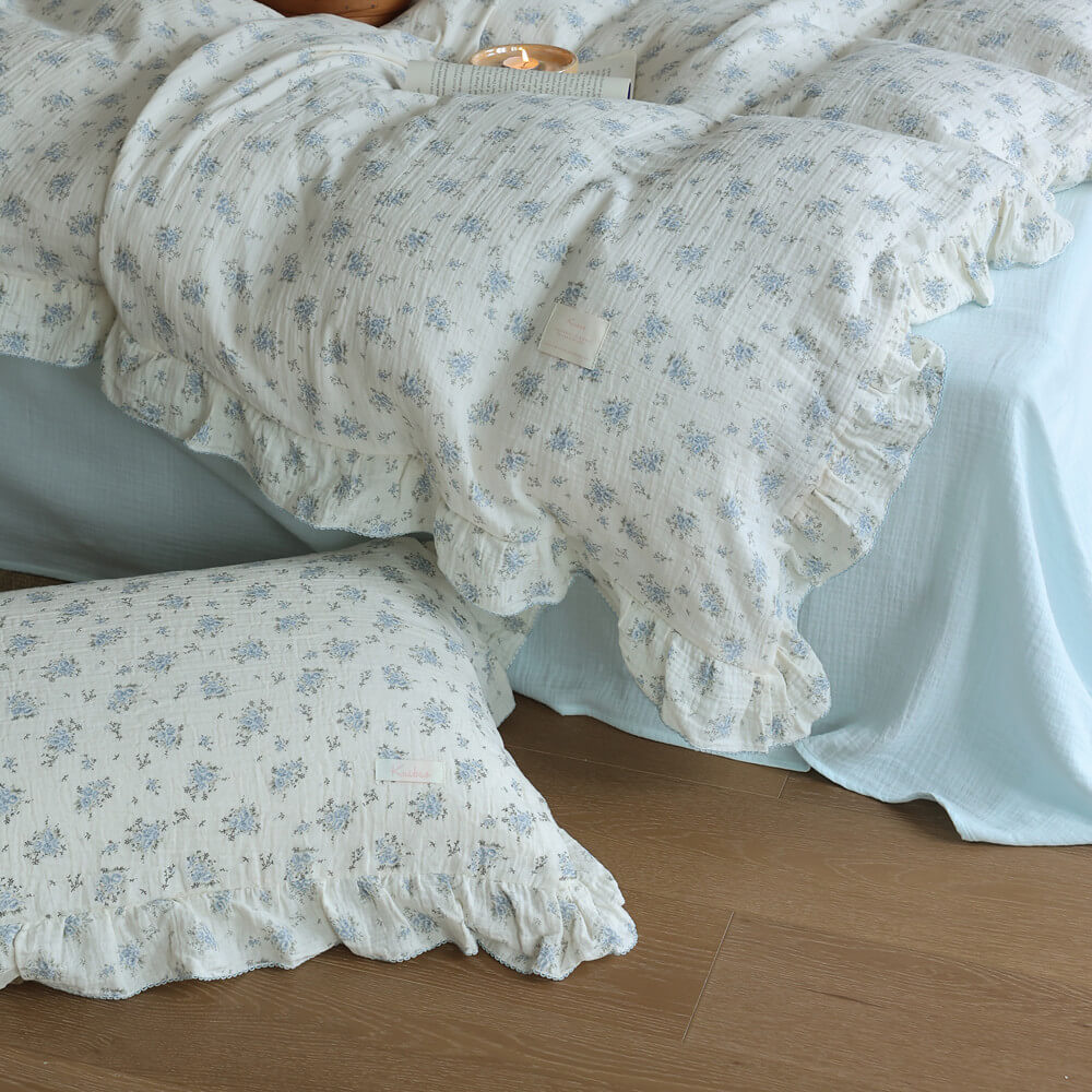 Blue posy duvet cover and pillowcase detail with ruffled edges and soft cotton muslin texture