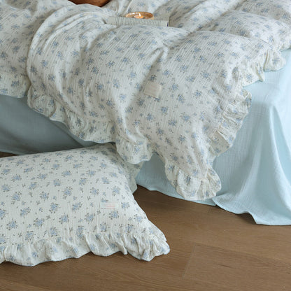 Blue posy duvet cover and pillowcase detail with ruffled edges and soft cotton muslin texture