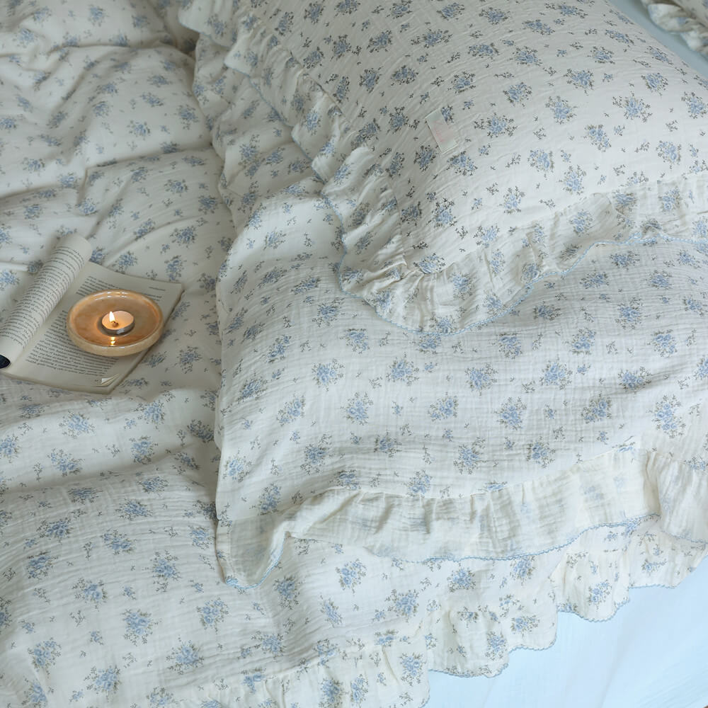 Close-up of blue floral ruffled bedding showing cotton muslin texture and delicate trim