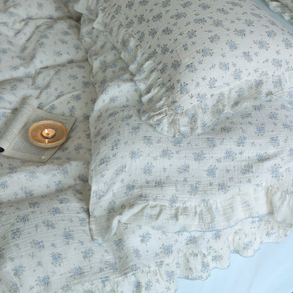 Close-up of blue floral ruffled bedding showing cotton muslin texture and delicate trim