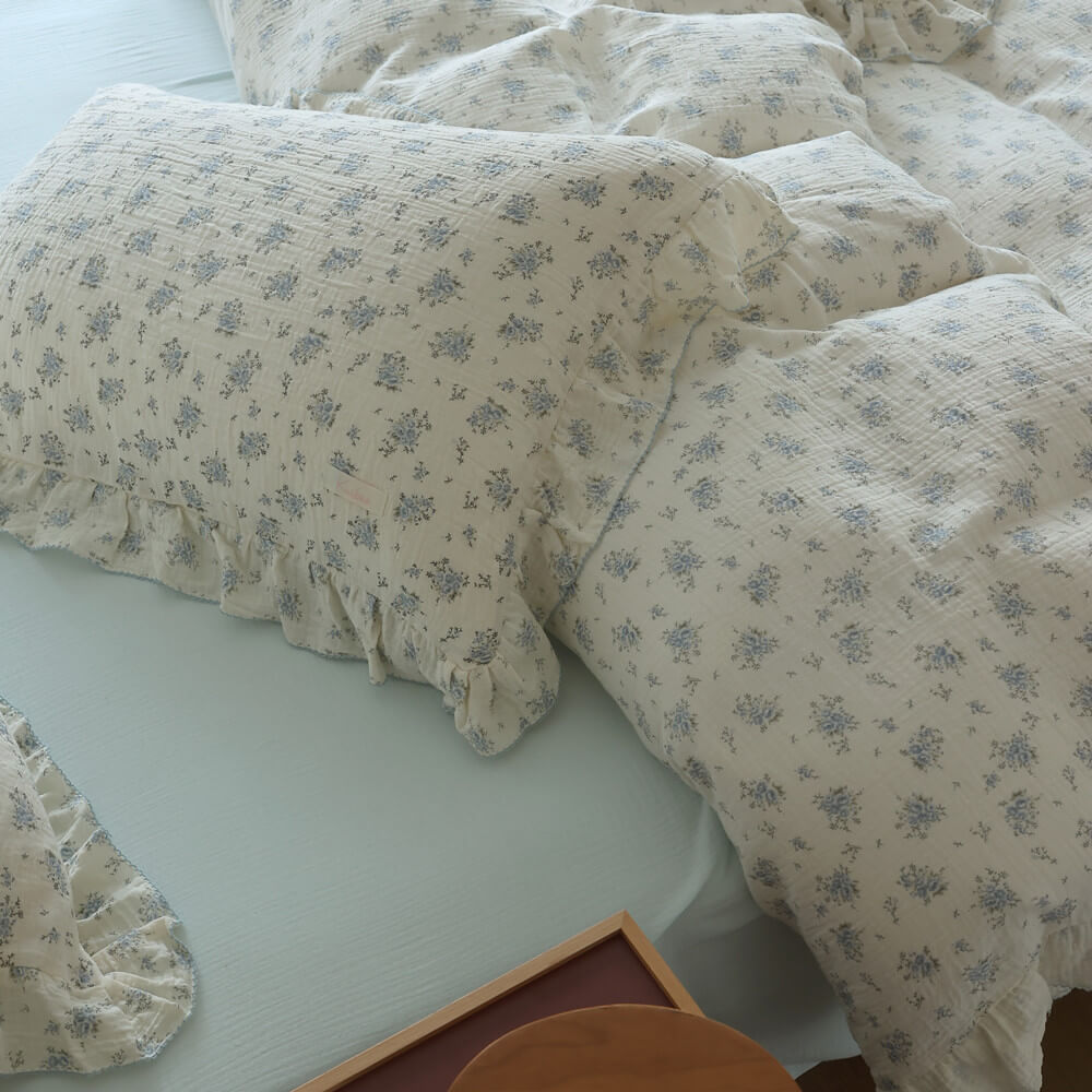 Ruffled pillowcase and duvet cover in blue posy floral cotton muslin with ivory base