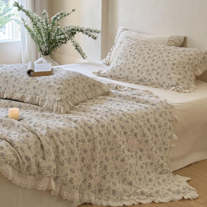 Aesthetic blue rose crinkled muslin cotton comforter spread neatly on a bed by a bright window, showcasing the romantic ruffled floral design and matching pillowcases.
