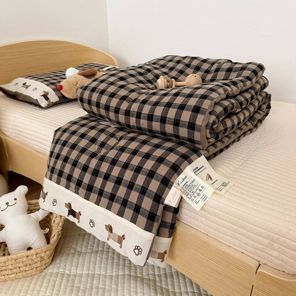 Plaid blanket with cartoon dog pattern on a bed