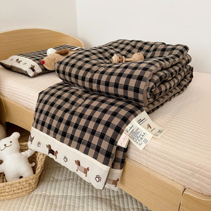 Plaid blanket with cartoon dog pattern on a bed
