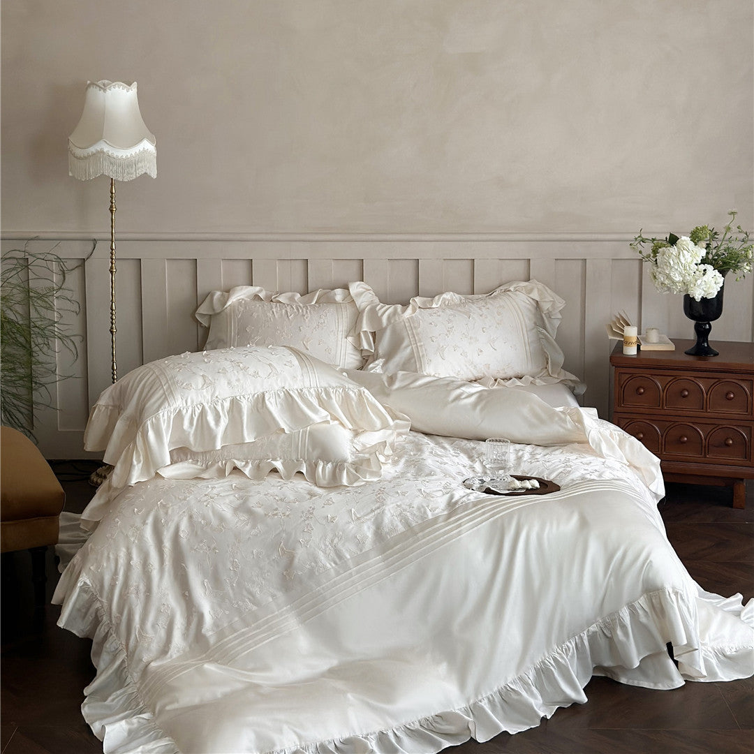 Luxurious ivory Butterfly Embroidered Bedding Set featuring ruffles and Tencel material on a bed.