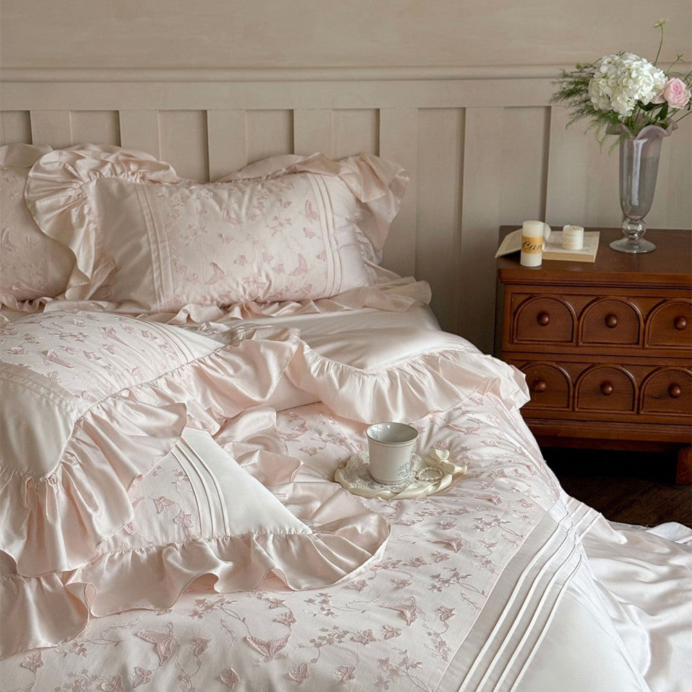 Styled close-up of the pink Butterfly Embroidered Bedding Set on the bed, highlighting ruffles.