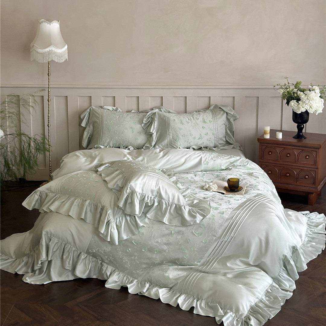 Full view of the light green Butterfly Embroidered Bedding Set with large ruffles on a large bed.