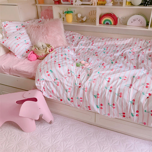 Children's bedroom with cherry-patterned bedding, pink elephant stool, and shelves with toys.