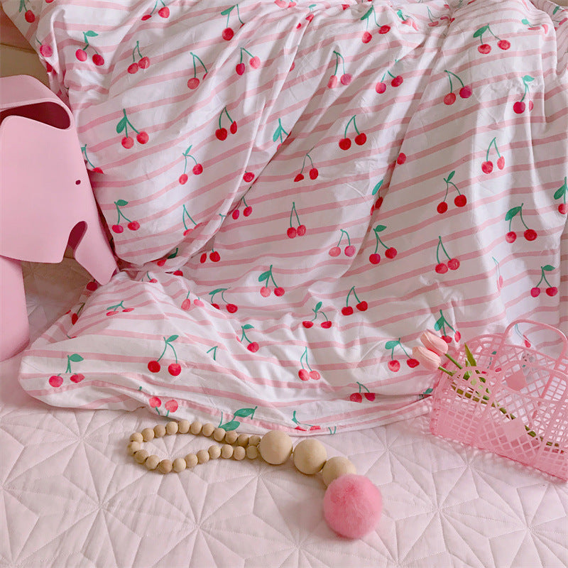 Pink and white striped fabric with cherry pattern on a textured surface