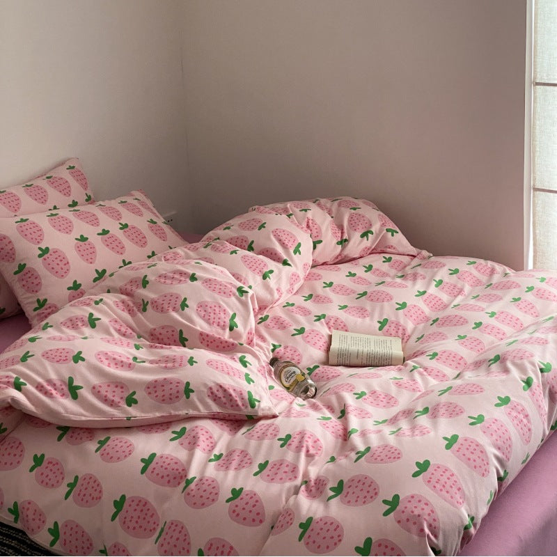 Pink strawberry bedding set with matching sheet and pillowcase on bed