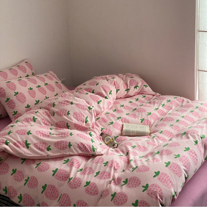 Pink strawberry bedding set with matching sheet and pillowcase on bed