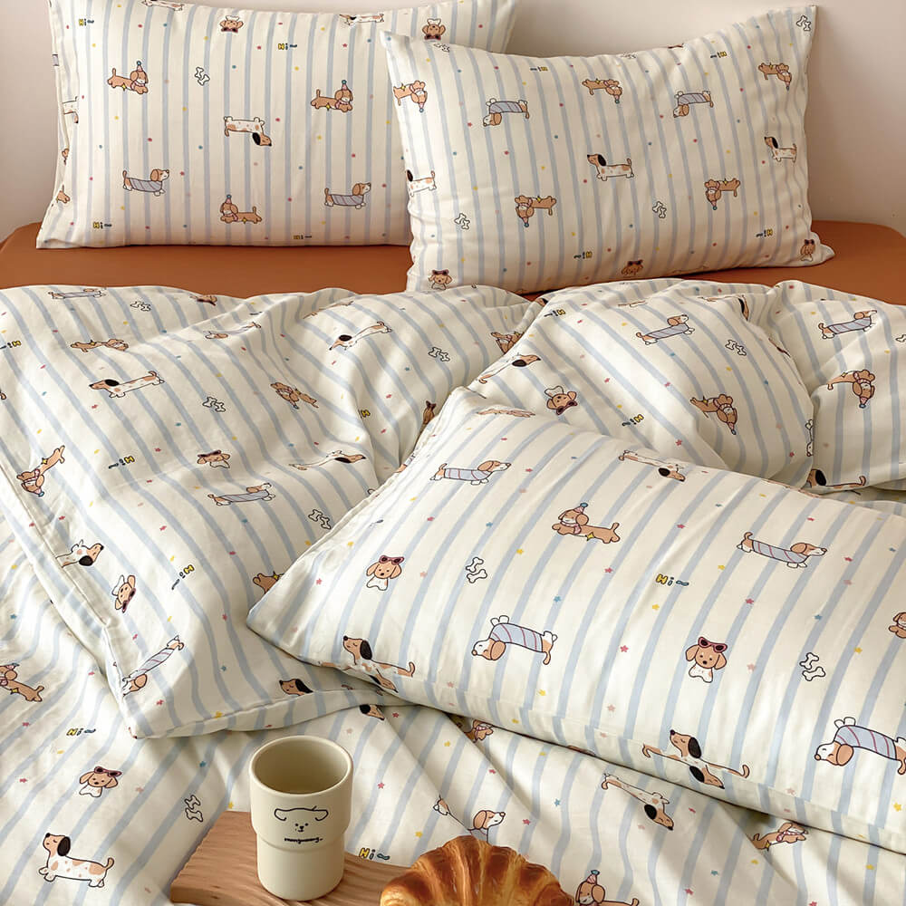Close-up of dachshund stripe kids bedding set with matching pillowcases, blue striped duvet cover, and rust sheet