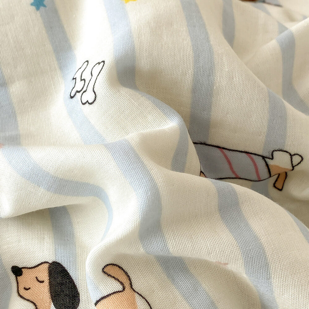Soft cotton muslin fabric close-up with pale blue stripes, dachshund dog print, star accents, and visible woven texture