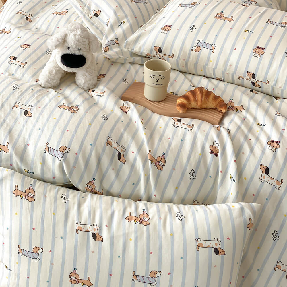 Cotton muslin dachshund bedding set close-up with blue stripes, playful dog motifs, and matching pillowcase
